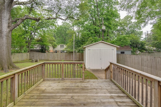 deck featuring an outdoor structure, a fenced backyard, a yard, and a storage shed