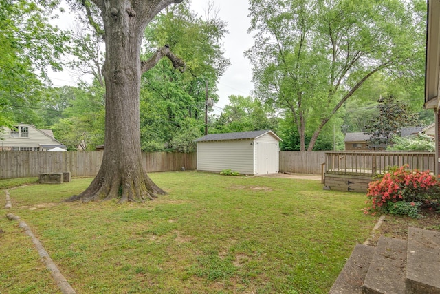 view of yard featuring an outdoor structure, a fenced backyard, a storage shed, and a deck