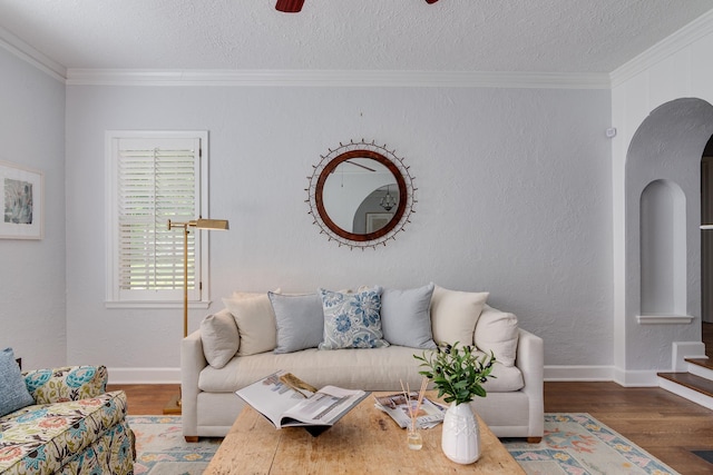 living room with ornamental molding, a textured ceiling, and wood finished floors