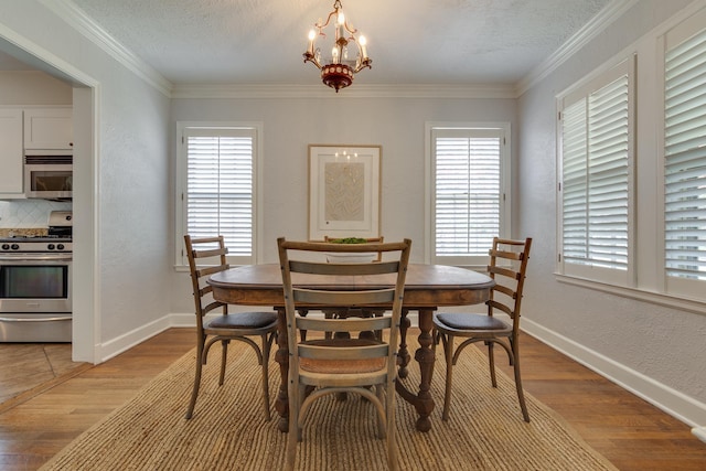 dining room featuring light wood-type flooring, ornamental molding, and a wealth of natural light
