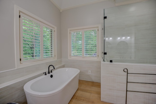 bathroom with tile walls, a tile shower, ornamental molding, and a freestanding bath
