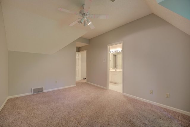 additional living space featuring carpet floors, a ceiling fan, and vaulted ceiling