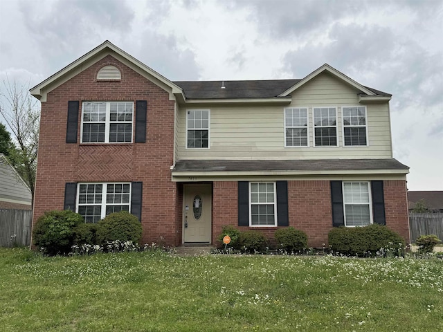 traditional-style home with brick siding, fence, and a front yard