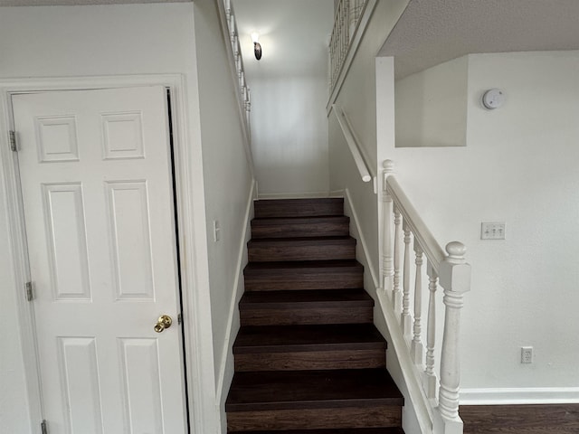 stairway with baseboards and wood finished floors
