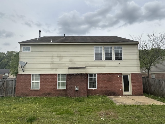 back of property featuring a lawn, a patio, brick siding, and a fenced backyard