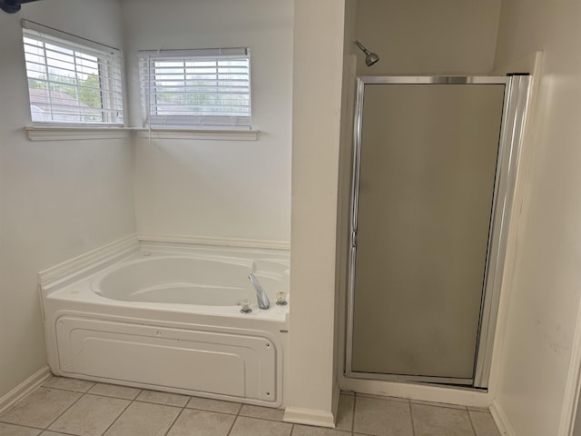 bathroom with tile patterned floors, a shower stall, baseboards, and a garden tub
