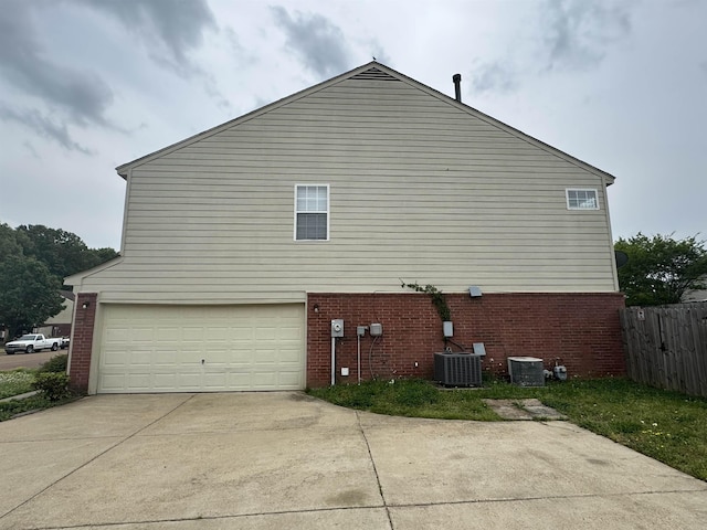 view of side of home featuring brick siding, a garage, and central air condition unit