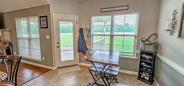 entryway featuring baseboards, a healthy amount of sunlight, and light tile patterned floors
