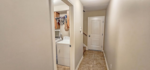 laundry area featuring light tile patterned floors, separate washer and dryer, baseboards, and laundry area