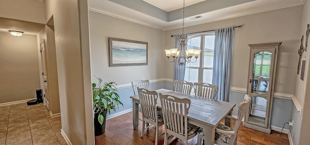 dining room featuring an inviting chandelier, baseboards, ornamental molding, and visible vents
