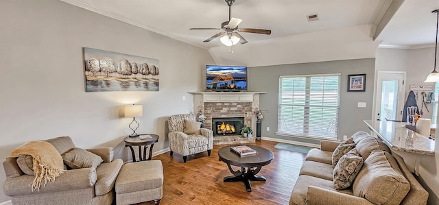 living room with visible vents, wood finished floors, a fireplace, baseboards, and ceiling fan