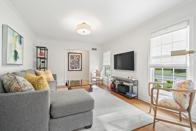 living room featuring baseboards, ornamental molding, and wood finished floors