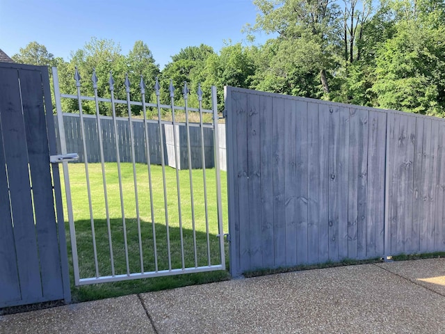 view of gate featuring fence and a yard