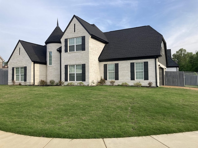 french provincial home featuring brick siding, fence, a shingled roof, and a front lawn