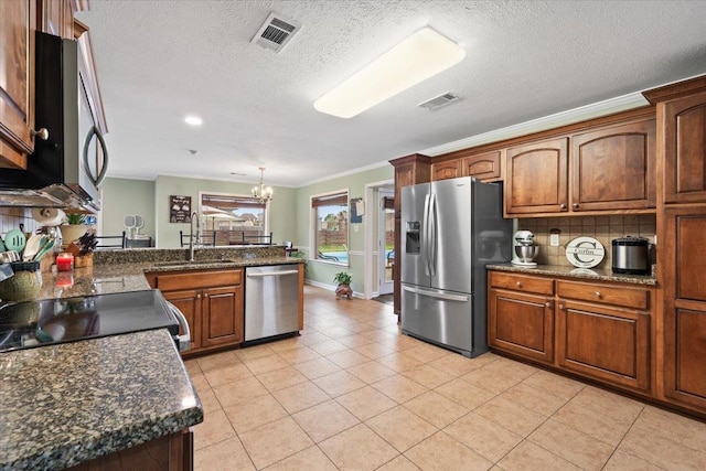 kitchen featuring visible vents, a sink, a textured ceiling, and appliances with stainless steel finishes