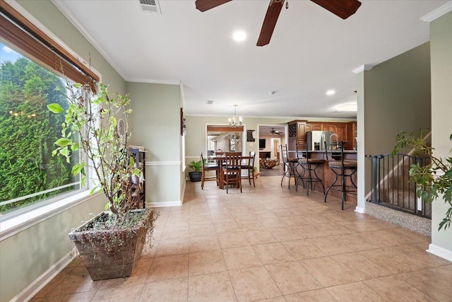 living room with crown molding, plenty of natural light, ceiling fan with notable chandelier, and visible vents