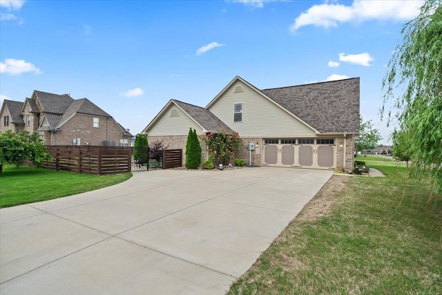 view of front of house featuring fence, a front yard, brick siding, an attached garage, and driveway