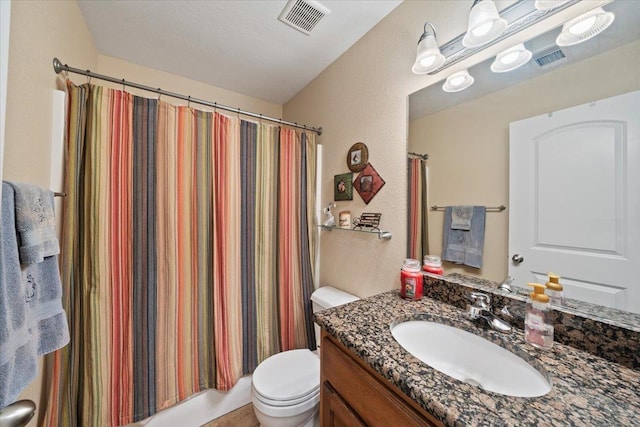 bathroom featuring toilet, a textured wall, visible vents, and vanity