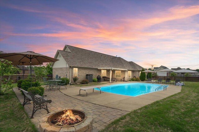 view of swimming pool featuring fence, a diving board, a fenced in pool, a patio area, and a fire pit