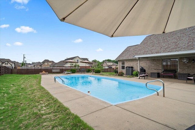 view of swimming pool featuring a lawn, central air condition unit, a fenced in pool, a fenced backyard, and a patio