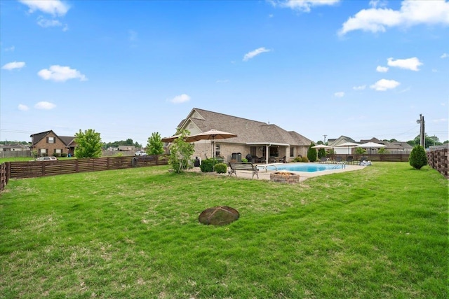 rear view of house featuring a fenced in pool, a fenced backyard, a yard, and a patio