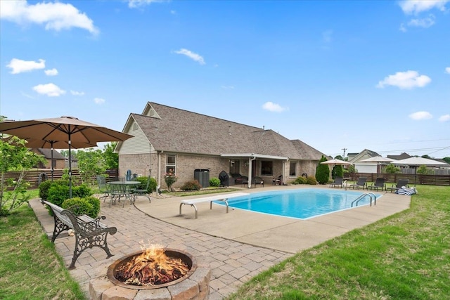 view of pool featuring fence, a patio, a fenced in pool, a diving board, and an outdoor fire pit