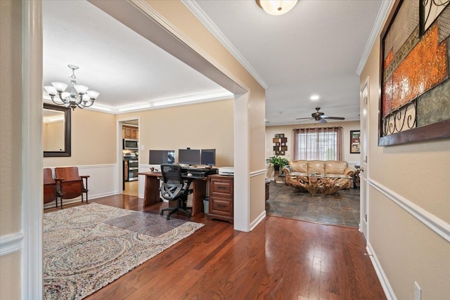 office space with dark wood-style flooring, baseboards, ornamental molding, and ceiling fan with notable chandelier