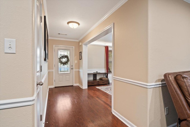 entryway with a textured wall, visible vents, ornamental molding, and dark wood-type flooring