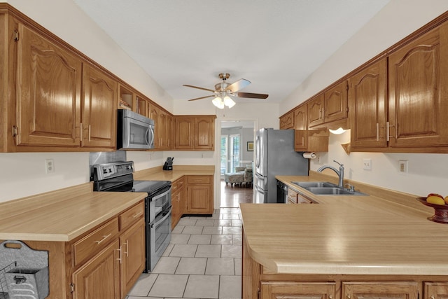 kitchen featuring a sink, light countertops, brown cabinets, a ceiling fan, and appliances with stainless steel finishes