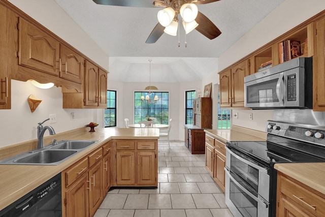 kitchen featuring a peninsula, ceiling fan, light countertops, a sink, and appliances with stainless steel finishes