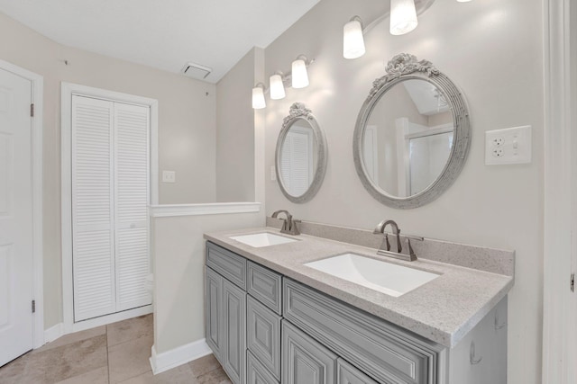 full bathroom featuring a closet, a sink, tile patterned floors, and double vanity