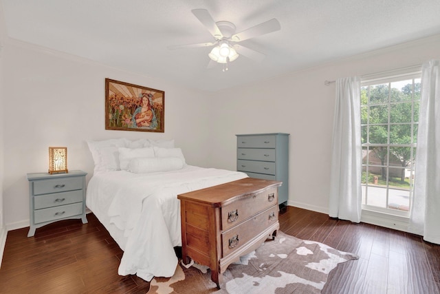 bedroom featuring crown molding, ceiling fan, baseboards, and dark wood-type flooring