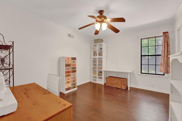 unfurnished office with visible vents, crown molding, wood finished floors, baseboards, and a ceiling fan