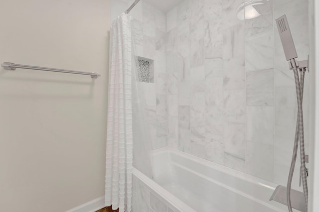 full bathroom with tiled shower / bath and baseboards