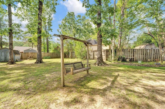 view of yard with an outbuilding, a shed, and a fenced backyard