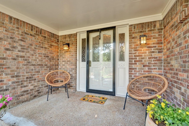 entrance to property featuring covered porch and brick siding