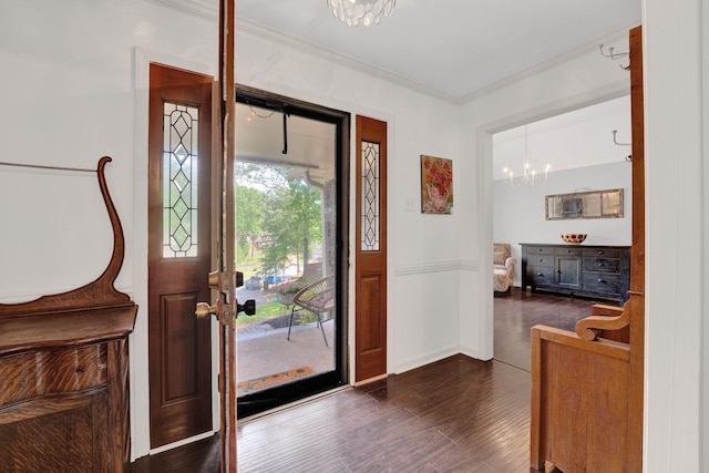foyer with an inviting chandelier, dark wood-style flooring, crown molding, and baseboards