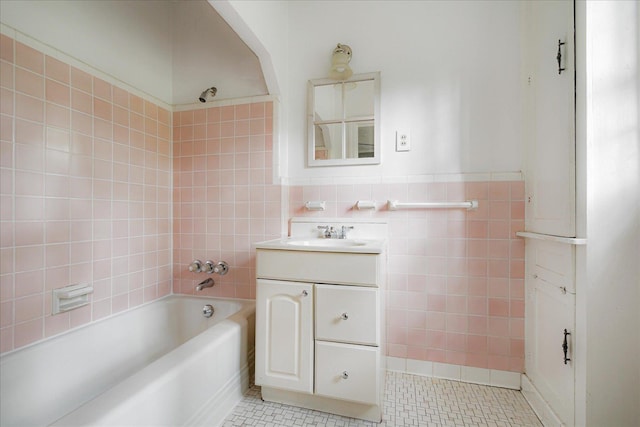 3537 Oakley Ave, Memphis, TN 38111 - bathroom with vanity, tile walls, a wainscoted wall, tile patterned floors, and shower / bath combination
