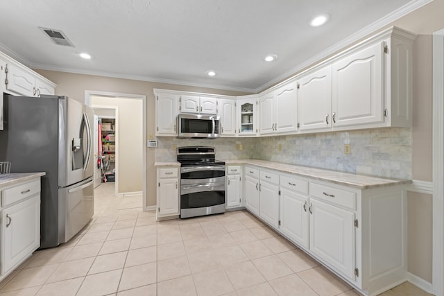 kitchen with appliances with stainless steel finishes, decorative backsplash, white cabinetry, and visible vents