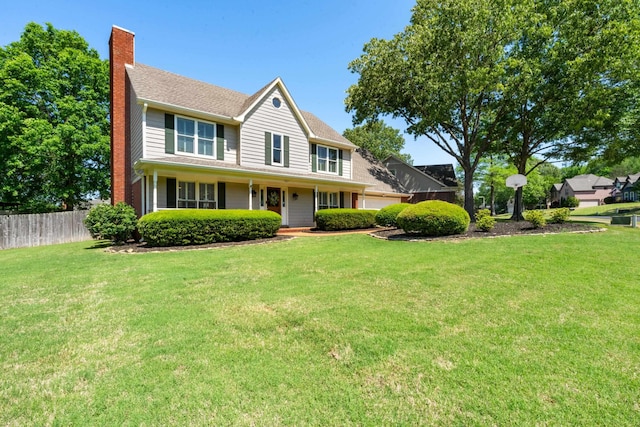 view of front of home featuring a porch, a chimney, a front yard, a garage, and fence