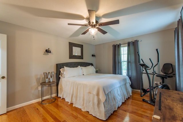 bedroom with light wood-type flooring, baseboards, and ceiling fan