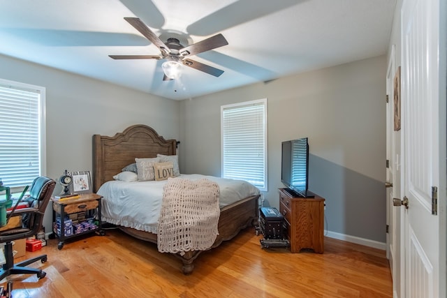 bedroom featuring a ceiling fan, baseboards, and light wood-style floors