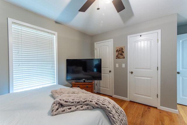 bedroom featuring baseboards, ceiling fan, and light wood-type flooring