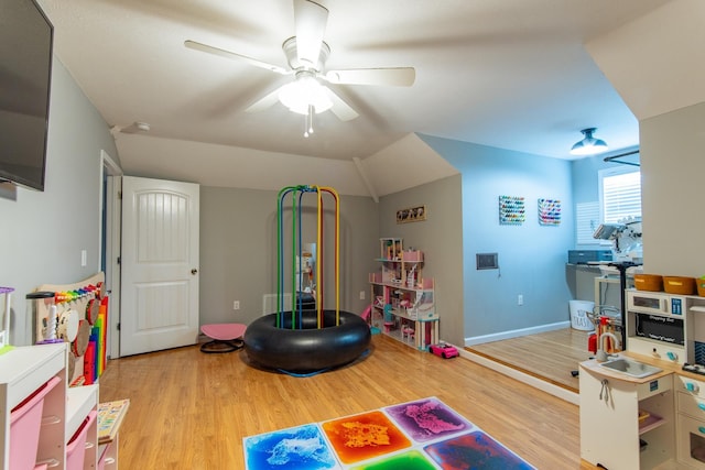 playroom with baseboards, a ceiling fan, and wood finished floors