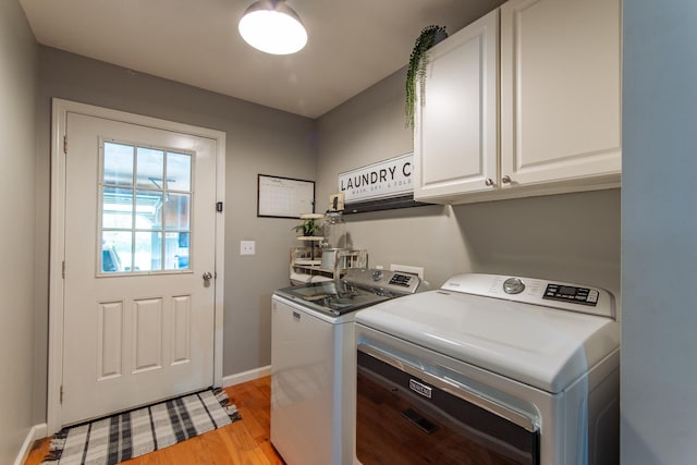 washroom featuring light wood-style floors, baseboards, cabinet space, and washer and dryer