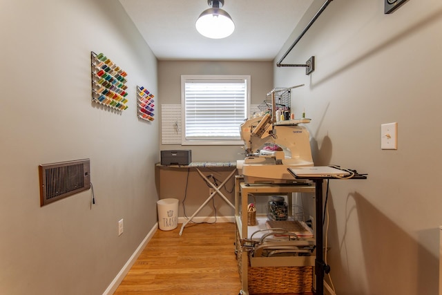 interior space featuring baseboards, wood finished floors, and visible vents