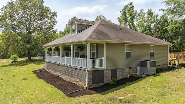 view of side of home featuring a lawn, a shingled roof, central air condition unit, and covered porch