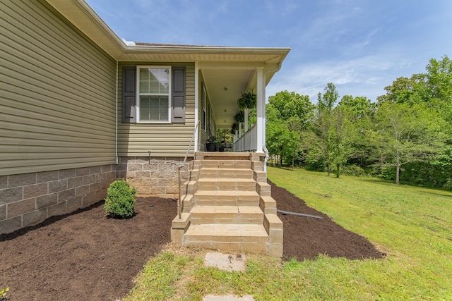 view of exterior entry featuring a yard