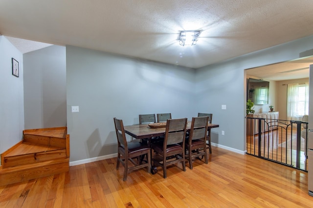 dining area with baseboards and light wood-type flooring