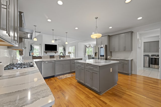 kitchen featuring gray cabinets, a ceiling fan, a sink, a peninsula, and stainless steel appliances